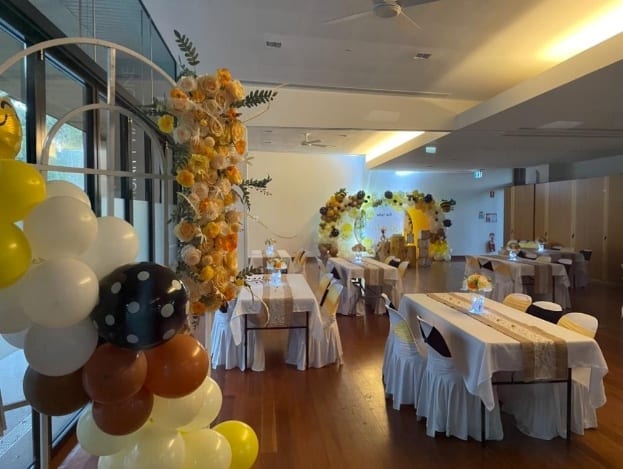 A room with tables and chairs and balloons Description automatically generated